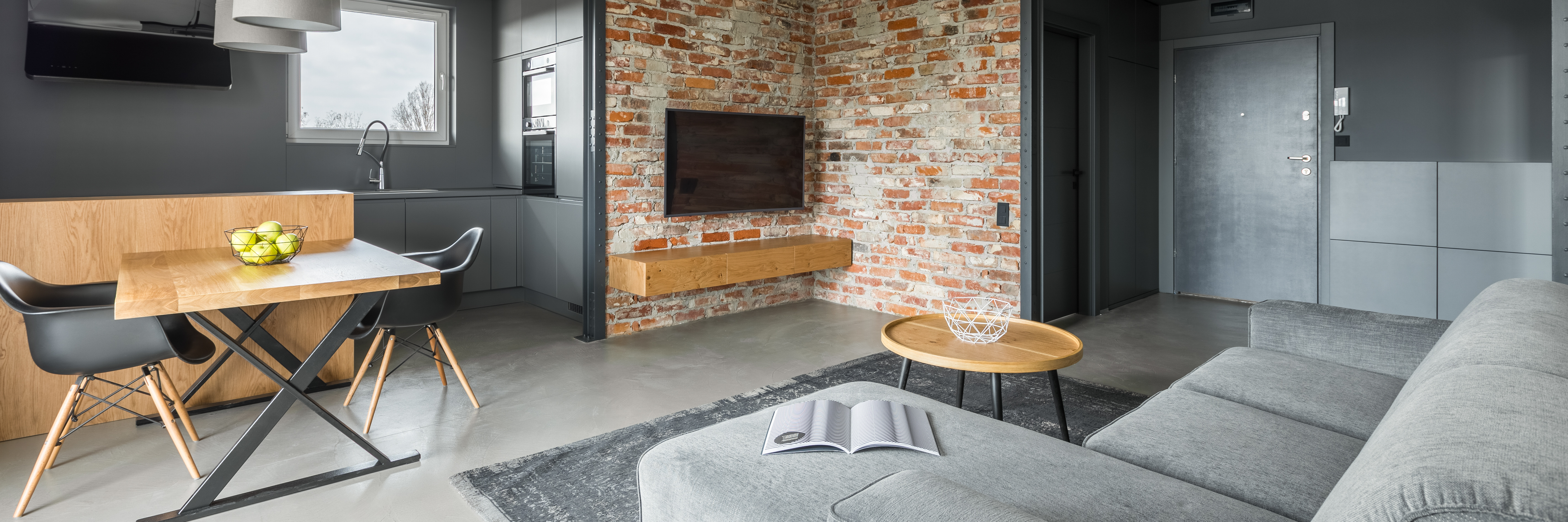 Panoramic view of home interior with brick wall in industrial style